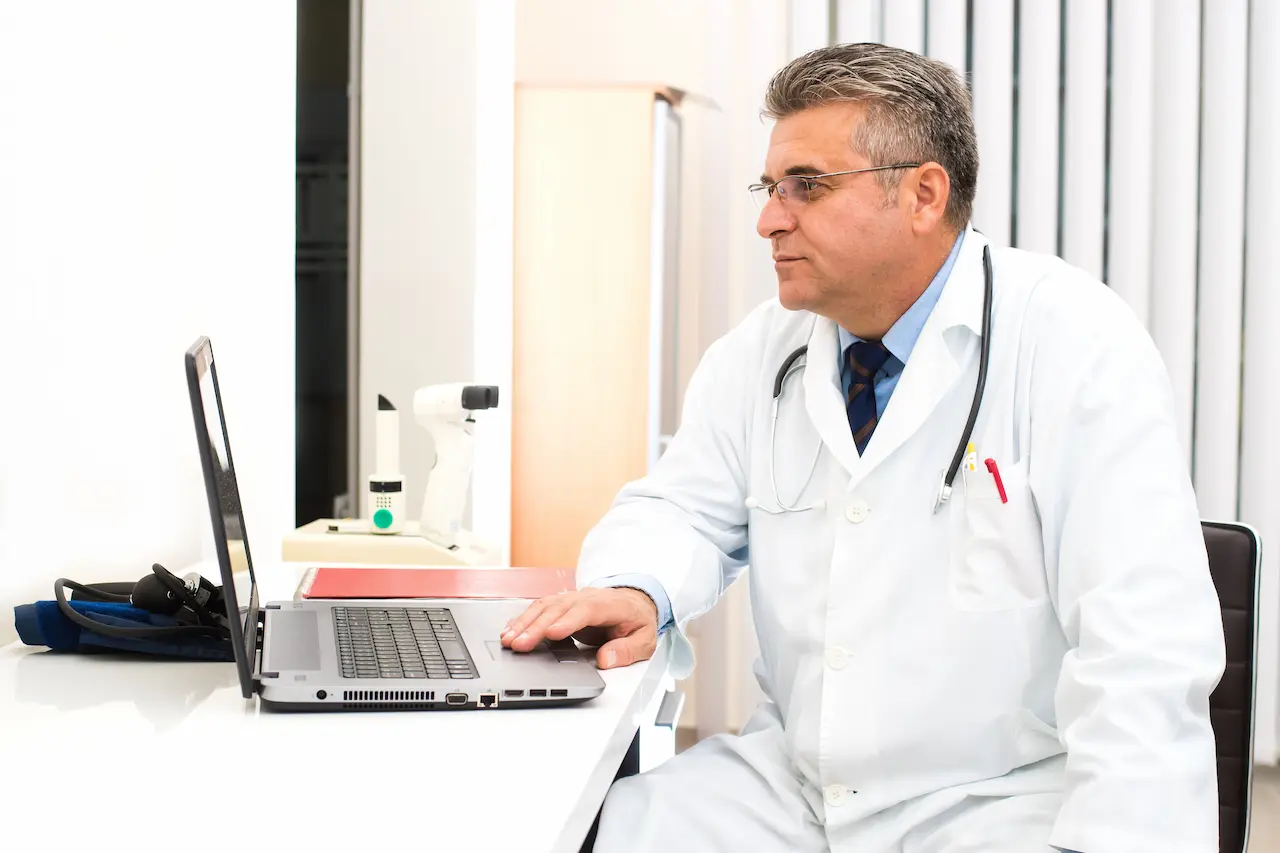 MIC Doctor looking at laptop